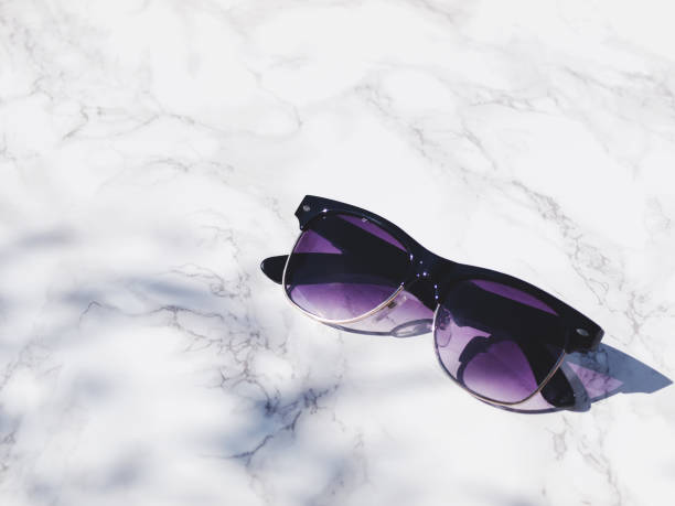 istock Stylish sunglasses isolated on white marble background in direct sunlight with shadows. Copy space. 865332146