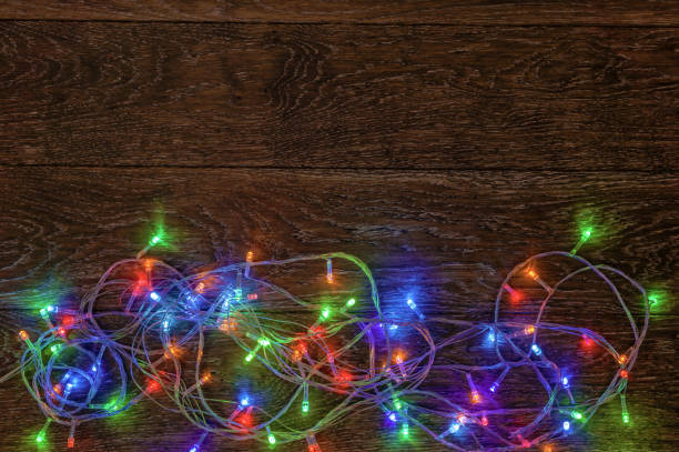 istock Burning LED garland on a dark wooden background. Preparation for 865332546