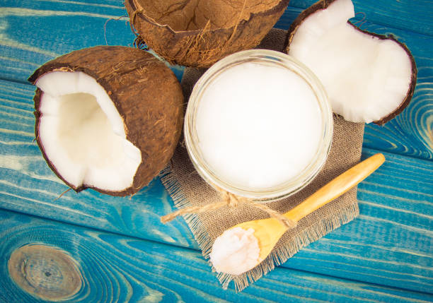 istock Coconut oil and fresh coconuts on a wooden table. 865332578