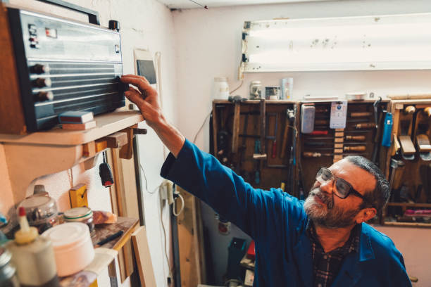 Workman turns on the radio Carpenter at the workshop plays the radio transistor stock pictures, royalty-free photos & images