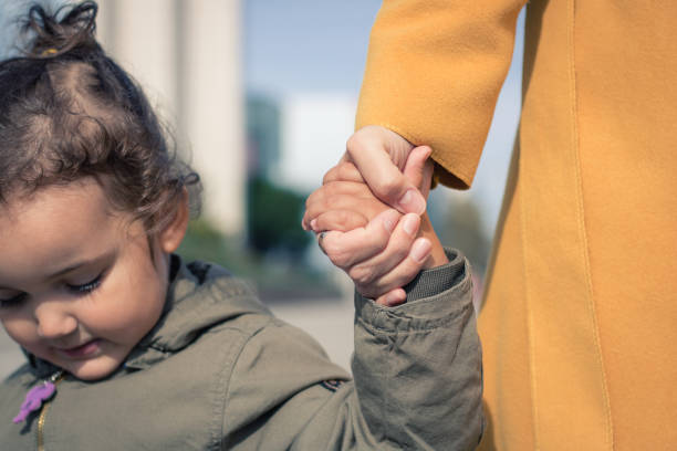 istock Mother and daughter holding hands. 865338534