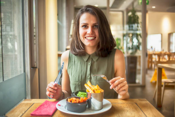 istock Young woman having lunch in restaurant 865349666