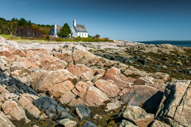 Chapel at the water's edge The small church of Port-au-Persil behind the rocks at low tide, Québec, Canada charlevoix photos stock pictures, royalty-free photos & images