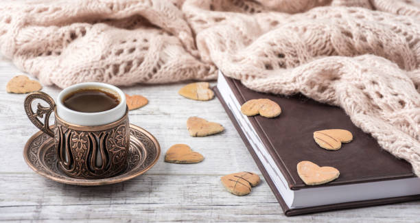 istock coffee and notebook with a knitted scarf on a table 865359612