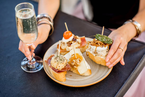 Set of pinchos on the table Beautiful and colorful set of pinchos, traditional spanish snack related to tapas, with glass of wine outdoors on the table tapas stock pictures, royalty-free photos & images