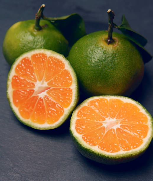 istock green Mandarin slices on black background 865371616