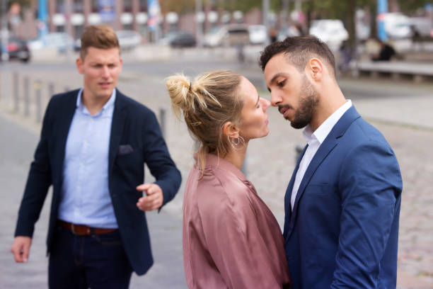 istock woman kissing man while another is upset 865378526