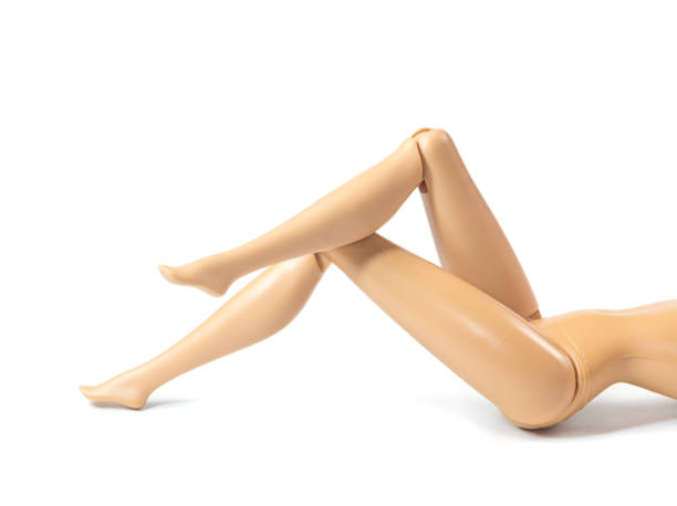 les belles jambes élancées de poupée de fille jolie figure faisant des gestes sexy isolés sur fond blanc - mannequin naked female doll photos et images de collection