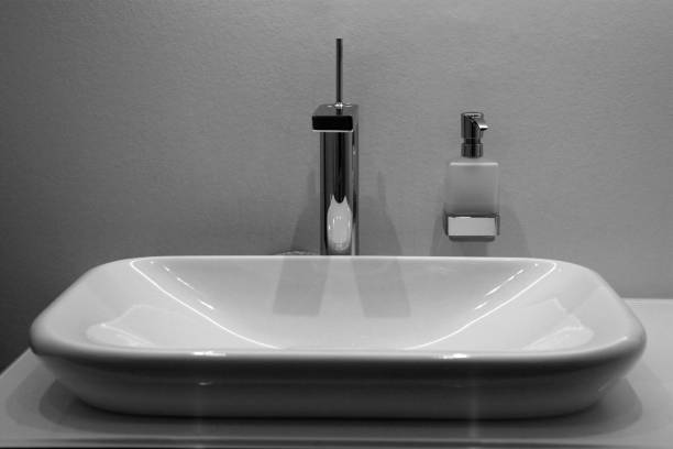 istock Ceramic washbasin with soad dispenser on white wall 865382098