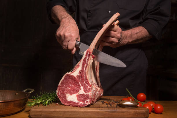Chef Cutting Beef Chef holds rib eye roast  to cutting. raw steak beef meat stock pictures, royalty-free photos & images