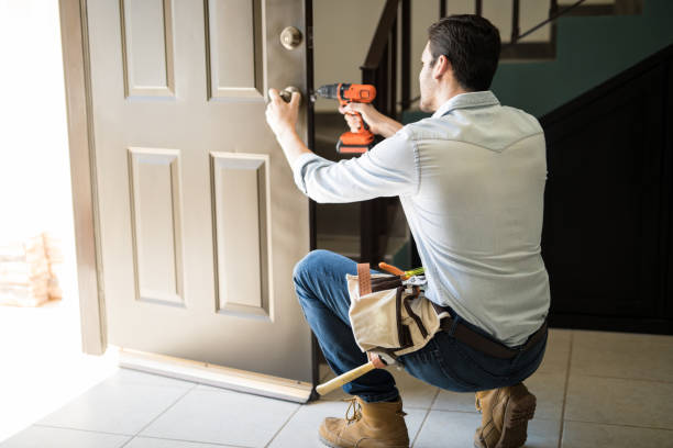 Young man fixing a door lock Rear view of a good looking man working as handyman and fixing a door lock in a house entrance craftsperson stock pictures, royalty-free photos & images