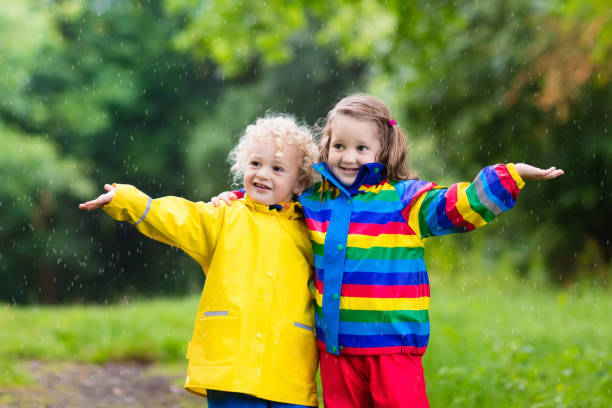istock Kids play in rain and puddle in autumn 865398690