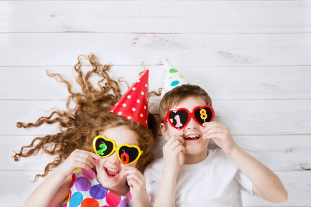 istock Funny children with sunglasses, hold 2018 candles 865399512
