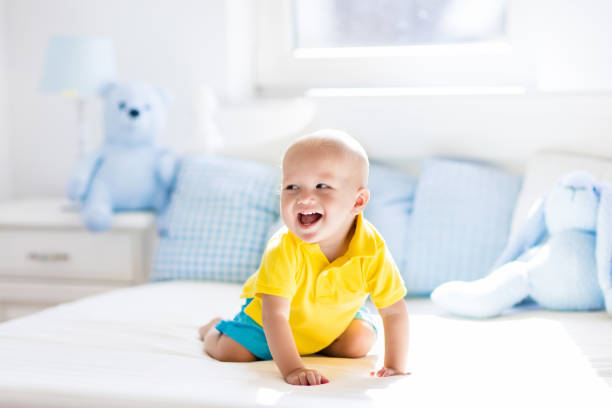 istock Baby boy playing on bed in sunny nursery 865400046