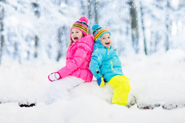 istock Kids playing in snow. Children play outdoors in winter snowfall. 865400378