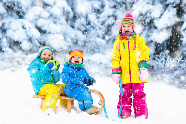 istock Kids on sleigh ride. Children sledding. Winter snow fun. 865401528