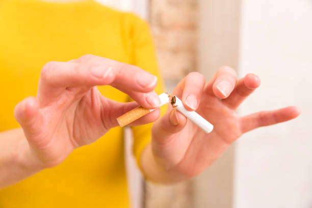 jeune femme se brise une cigarette, quittez la notion de tabagisme - pollution free photos et images de collection