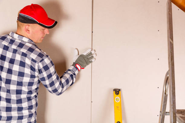 istock Construction worker holding gypsum board. Attic renovation. Installation of drywall 865406876