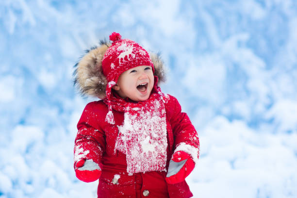istock Baby playing with snow in winter. 865409914