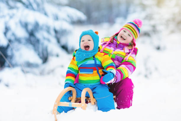 istock Kids on sleigh ride. Children sledding. Winter snow fun. 865410154