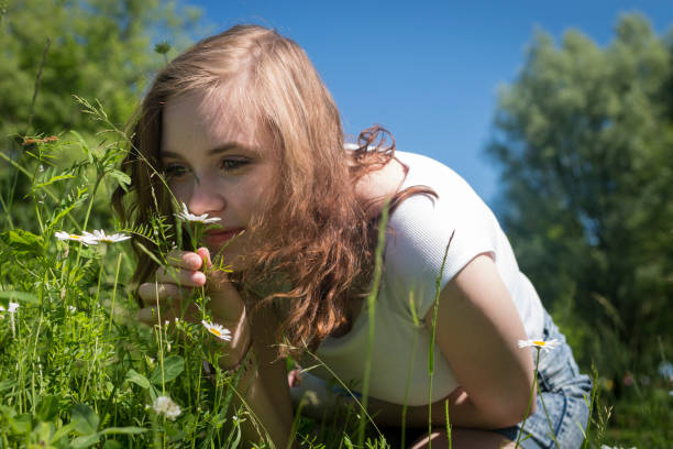 istock A woman smells a flower 865410266