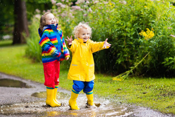 istock Kids play in rain and puddle in autumn 865425082