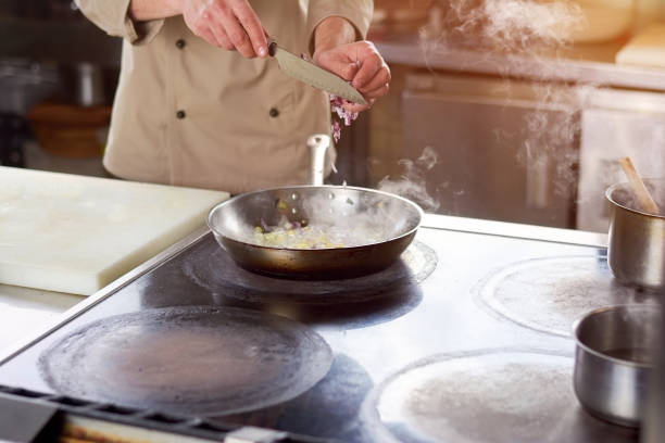 istock Chef cutting onion into frying pan. 865425126