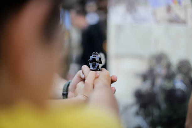 istock A boy aims a 9 mm pistol 865427666
