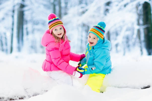 istock Kids playing in snow. Children play outdoors in winter snowfall. 865428124
