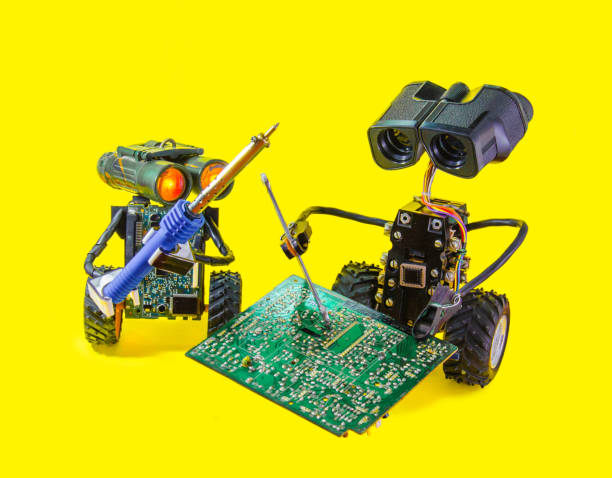 istock Two pretty cheerful robot repair printed circuit board with soldering iron 865428230