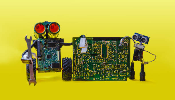 istock Two pretty cheerful robot repair printed circuit board with spanner 865428260