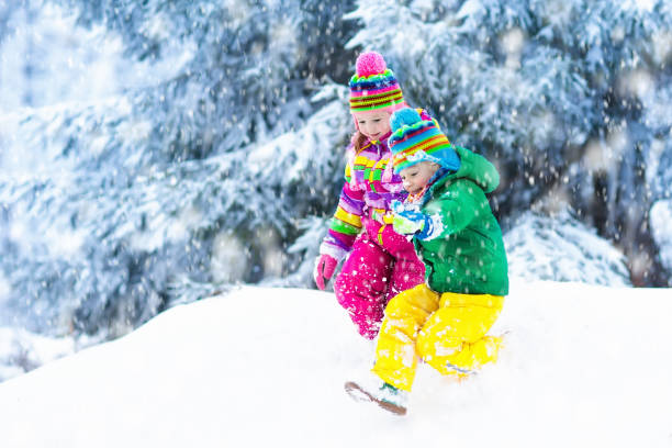 istock Kids playing in snow. Children play outdoors in winter snowfall. 865428312