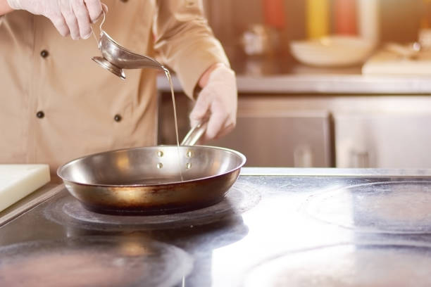 istock Chef pouring oil in frying pan. 865428876
