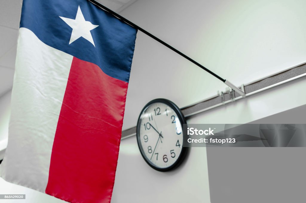 Texas high school classroom flag, clock. Texas high school or university classroom with focus on state flag and clock.  Whiteboard background. Texas Stock Photo