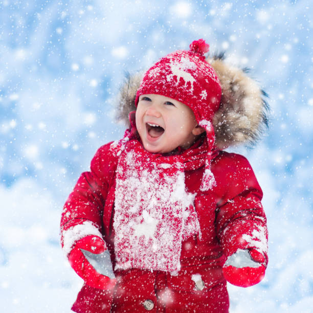 istock Baby playing with snow in winter. 865431642