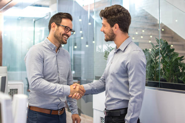 istock Two smiling business men shaking hands together after successful meeting. 865432310