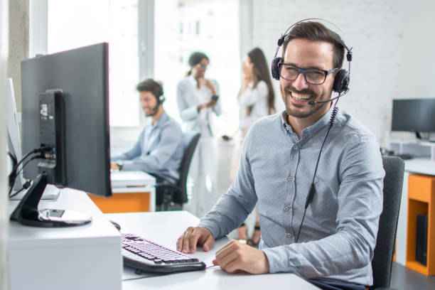 happy young male customer support executive working in office. - receptionist customer service customer service representative imagens e fotografias de stock