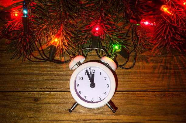 istock New Year's lights and clock on a wooden table, top view. 865435174