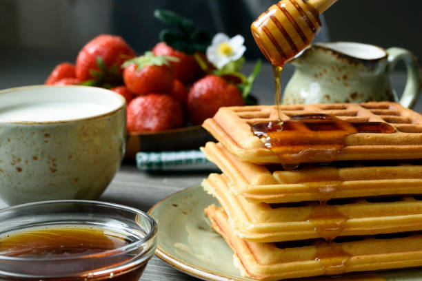 istock Belgian waffles with honey and fresh berries:  strawberry and red currants. 865435452