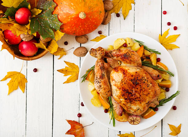 istock Roasted turkey garnished with cranberries on a rustic style table decorated with pumpkins, orange, apples and autumn leaf. Thanksgiving Day. Flat lay. Top view 865439428
