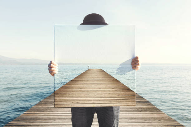 Man holding surreal painting of a boardwalk Man holding surreal painting of a boardwalk hiding stock pictures, royalty-free photos & images