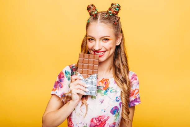istock Woman with playful look bites huge chocolate 865448688