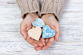 Heart-shaped cookie in woman's hands holiday cookies