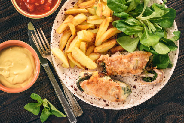 istock Pork roulades with spinach and cheese filling, served with fried potatoes. 865452376