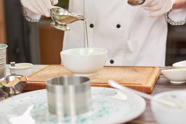 istock Chef pouring oil in white bowl. 865459740