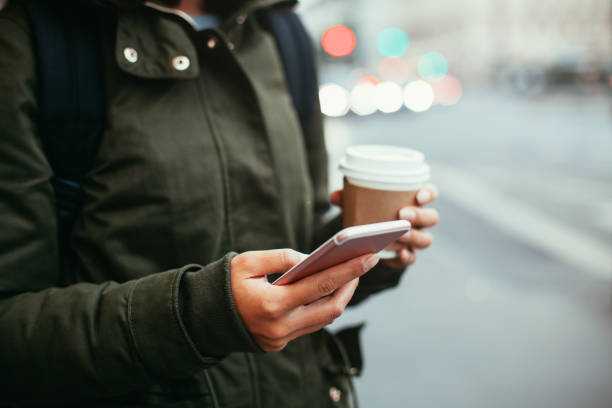 istock Woman using smart phone and holding coffee 865463390