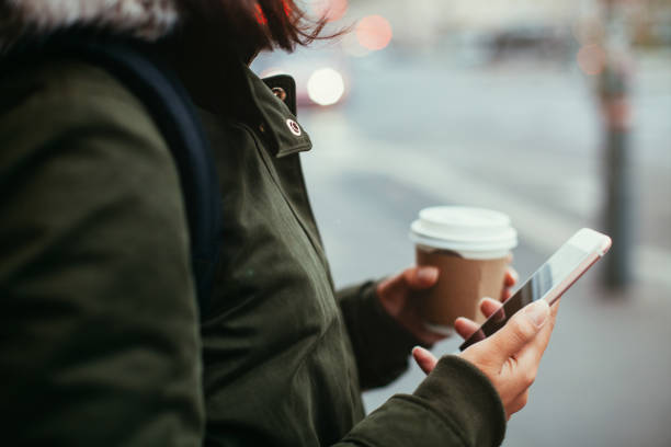 istock Woman using smart phone and holding coffee 865463568