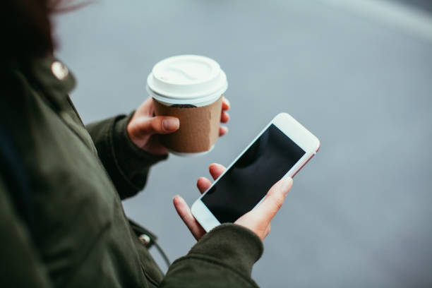 istock Woman using smart phone and holding coffee 865463636