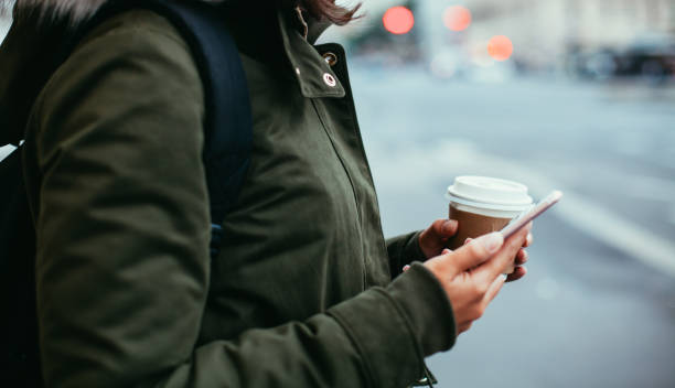 istock Woman using smart phone and holding coffee 865463926