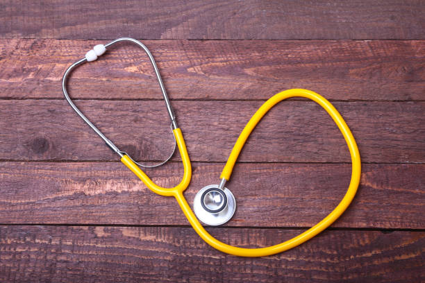 istock Medical stethoscope and tablets isolated on wooden background 865464492